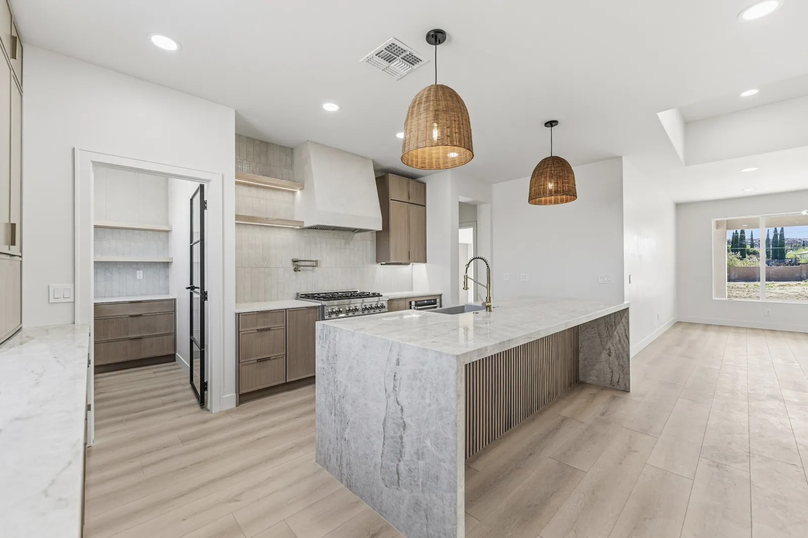 Open plan kitchen and living space in a new build with a black steel frame door
